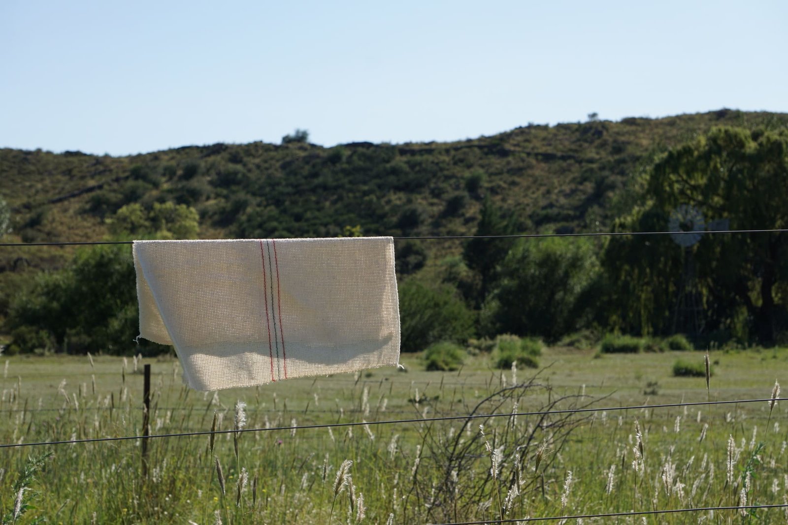 Rejilla Franciotex secándose al sol sobre un alambre de campo, demostrando su durabilidad y resistencia en condiciones exteriores y rurales.